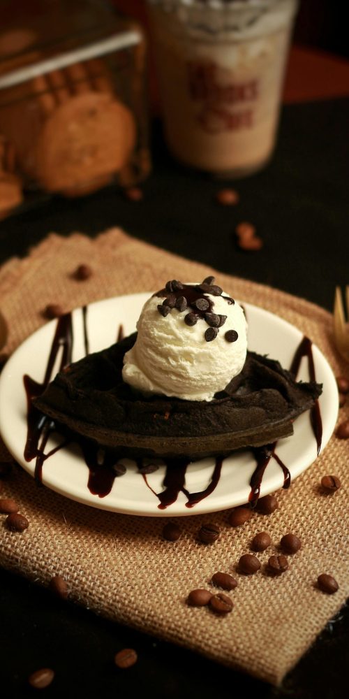 Luxurious chocolate waffle dessert topped with ice cream and chocolate chips for an indulgent treat.